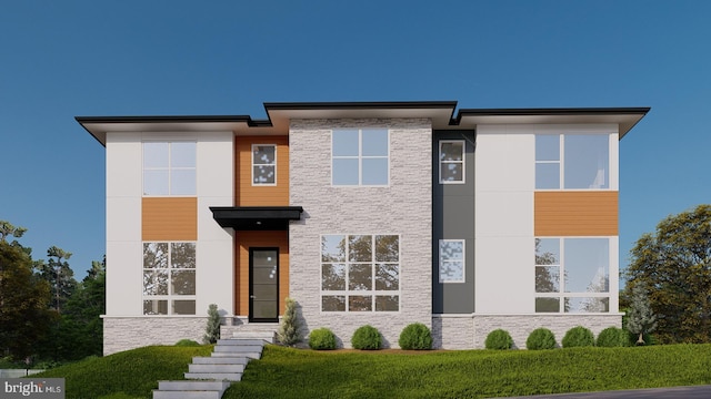 modern home featuring a front yard and stone siding