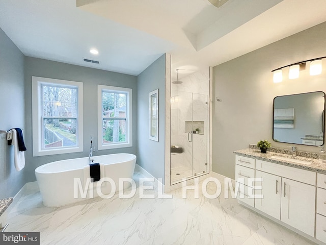 full bathroom featuring a shower stall, vanity, visible vents, a freestanding bath, and baseboards