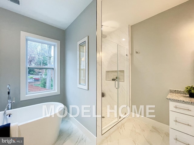 bathroom with a stall shower, a freestanding tub, marble finish floor, and baseboards