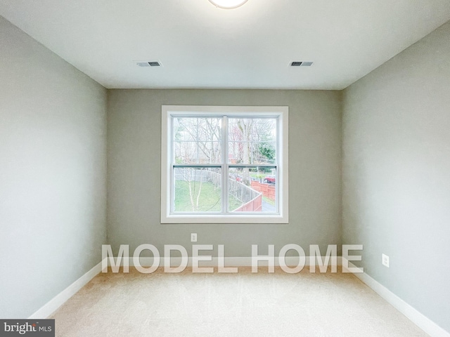 empty room featuring baseboards, visible vents, and carpet floors