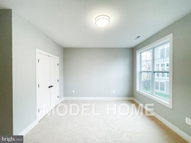 unfurnished bedroom featuring carpet floors, baseboards, and visible vents
