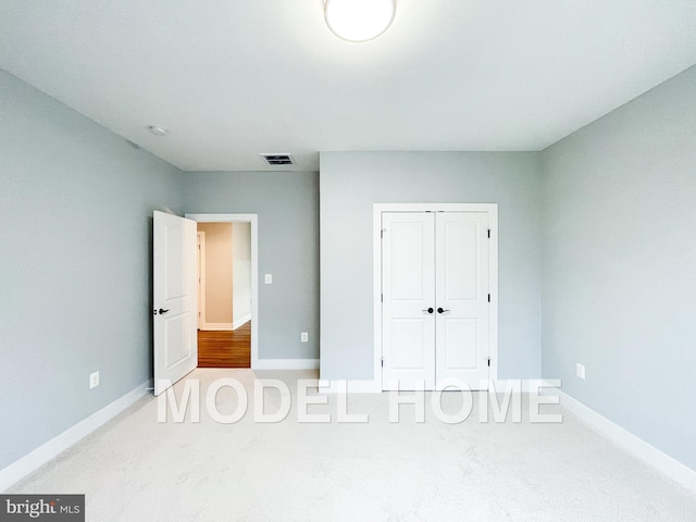 unfurnished bedroom with carpet flooring, visible vents, and baseboards