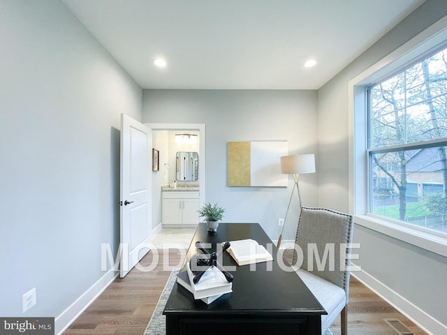 office space featuring light wood-style flooring, baseboards, and plenty of natural light