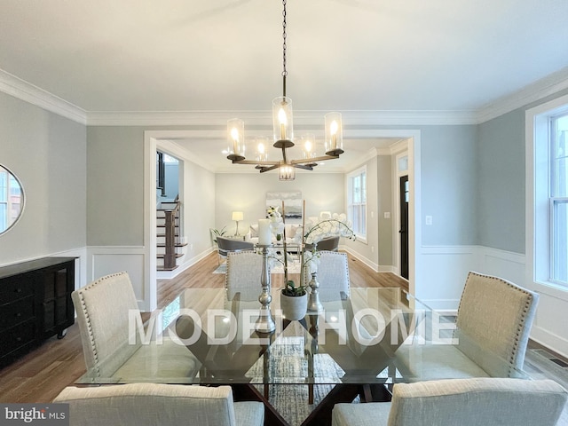 dining area with stairway, an inviting chandelier, ornamental molding, and wood finished floors