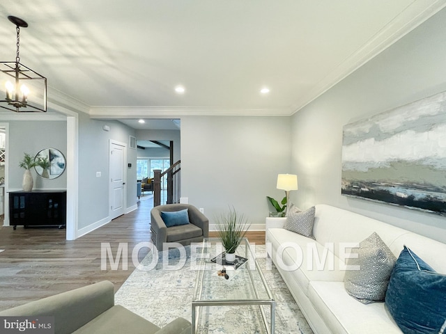 living room with ornamental molding, hardwood / wood-style flooring, and an inviting chandelier