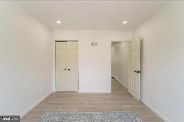 unfurnished bedroom featuring light hardwood / wood-style floors and a closet