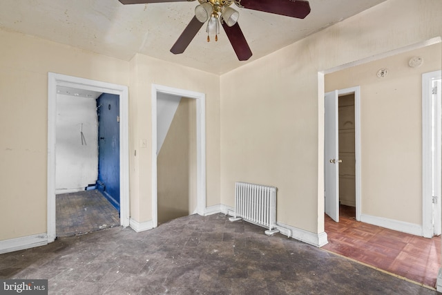 interior space featuring ceiling fan, radiator, and dark parquet flooring