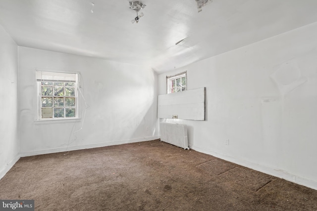 carpeted spare room featuring radiator