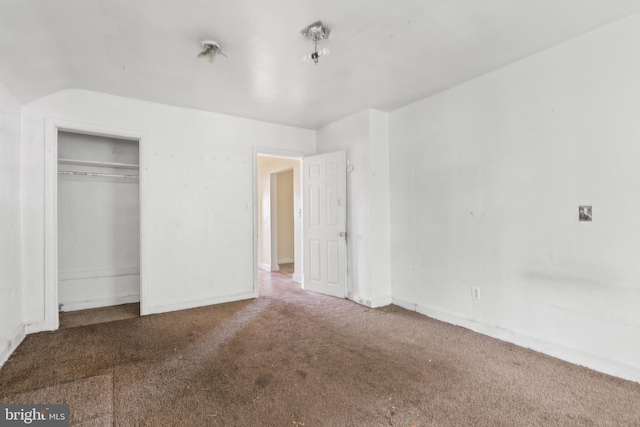 unfurnished bedroom with a closet, vaulted ceiling, and carpet