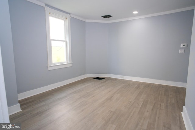 spare room with crown molding and hardwood / wood-style floors