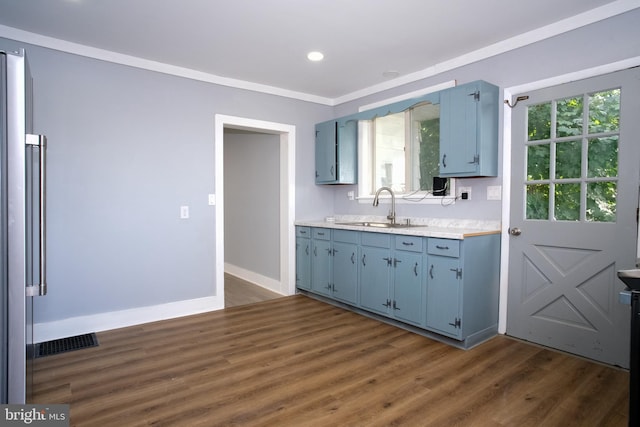 kitchen featuring ornamental molding, blue cabinetry, sink, and dark hardwood / wood-style flooring