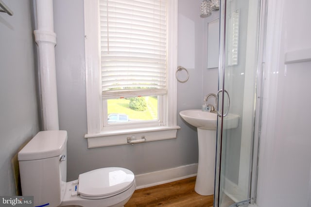 bathroom with an enclosed shower, hardwood / wood-style floors, and toilet