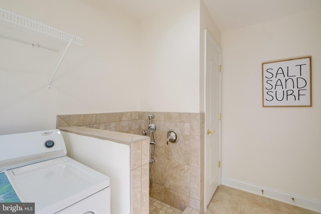 clothes washing area with washer / clothes dryer and light tile patterned floors