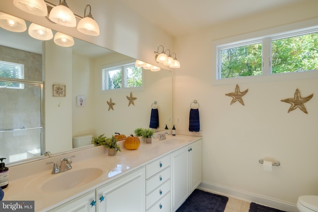 bathroom with vanity, plenty of natural light, toilet, and a shower with door