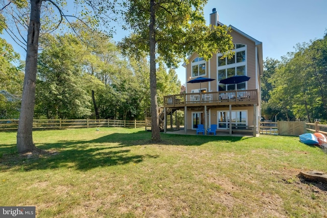 rear view of house with a patio area, a yard, and a wooden deck