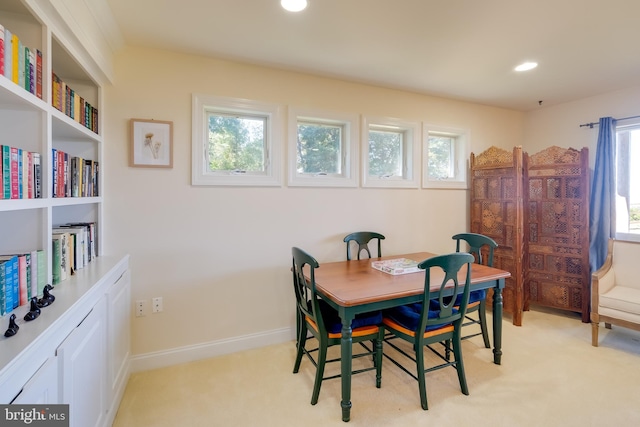 dining room featuring light colored carpet and a healthy amount of sunlight