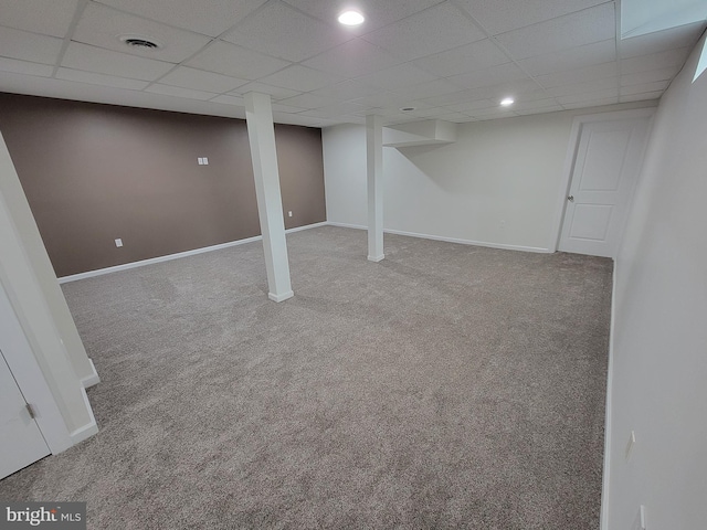 basement featuring carpet and a paneled ceiling