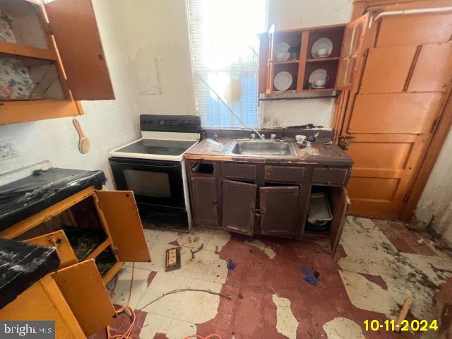 5426 Trinity St, Philadelphia, PA 19143 - kitchen with open shelves, black range with electric cooktop, and a sink