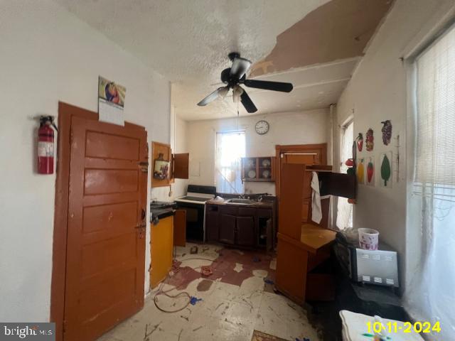 5426 Trinity St, Philadelphia, PA 19143 - kitchen with dark countertops, a ceiling fan, a sink, and electric stove