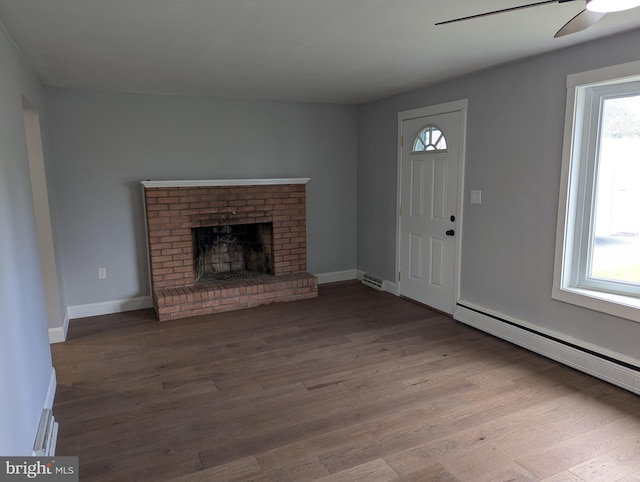 unfurnished living room featuring ceiling fan, light hardwood / wood-style flooring, a brick fireplace, and a baseboard heating unit