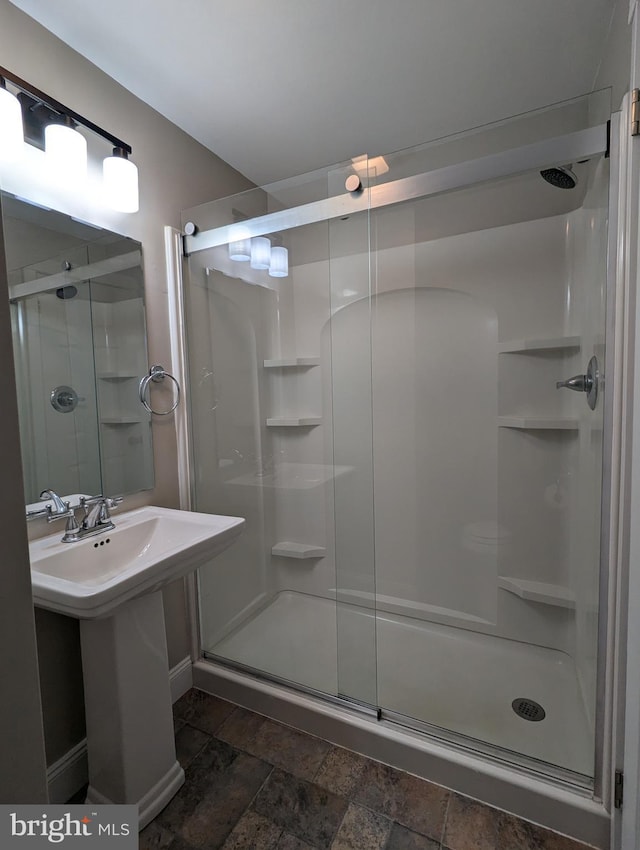 bathroom with a shower with door and sink