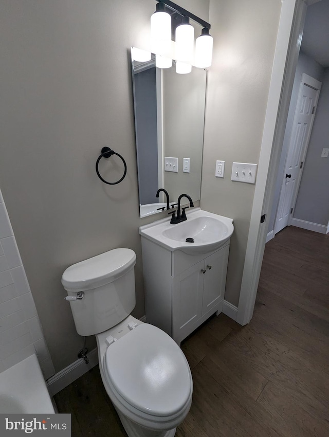 bathroom featuring toilet, hardwood / wood-style floors, and vanity