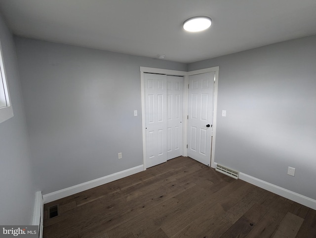 unfurnished bedroom featuring dark hardwood / wood-style flooring