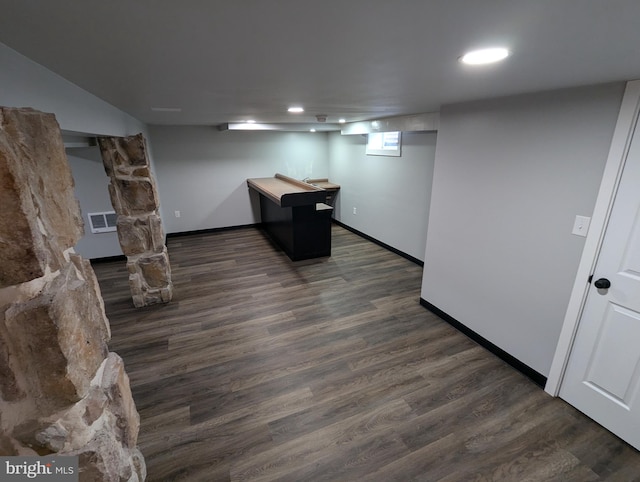 basement with dark hardwood / wood-style floors