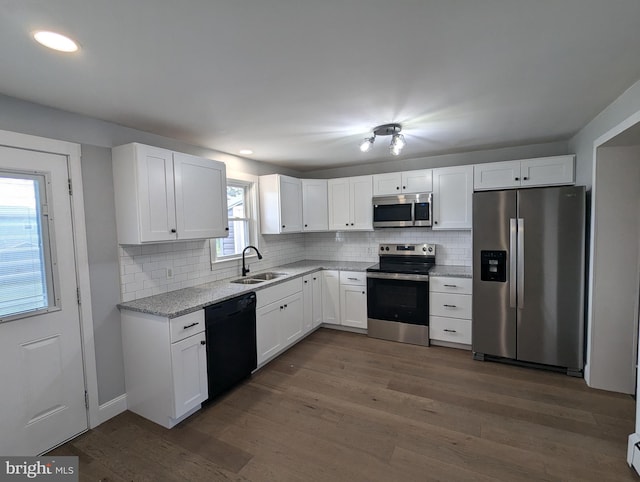 kitchen with a wealth of natural light, sink, white cabinetry, and stainless steel appliances