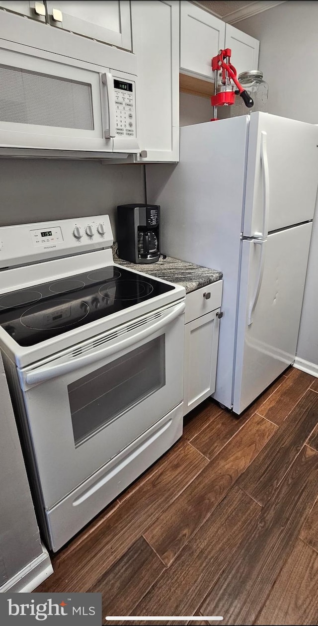 kitchen with white appliances, light stone countertops, white cabinetry, and dark hardwood / wood-style flooring