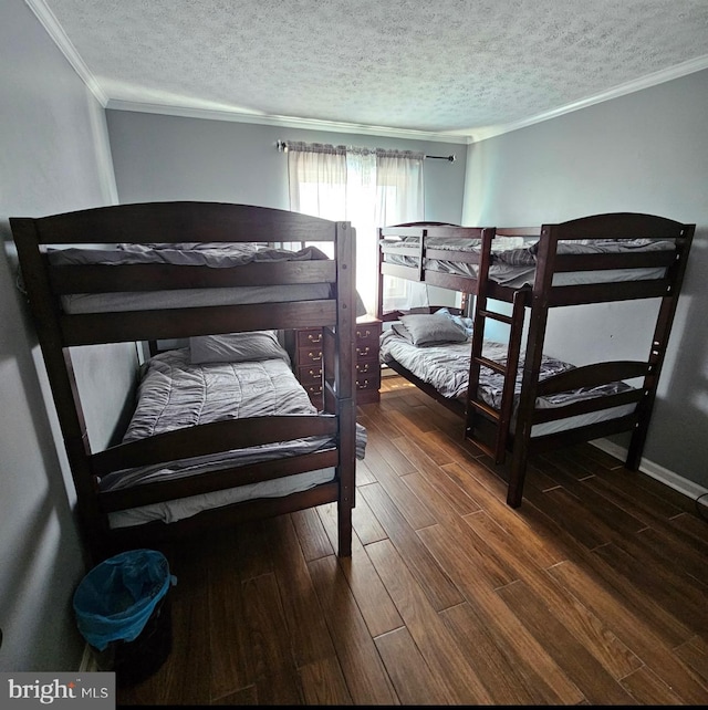 bedroom with a textured ceiling, crown molding, and dark hardwood / wood-style floors