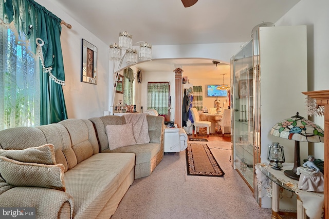 carpeted living room with a notable chandelier