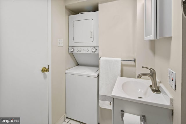 laundry room featuring stacked washer / drying machine, sink, and light tile patterned floors