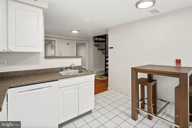 kitchen with sink, light tile patterned floors, white cabinetry, and dishwasher