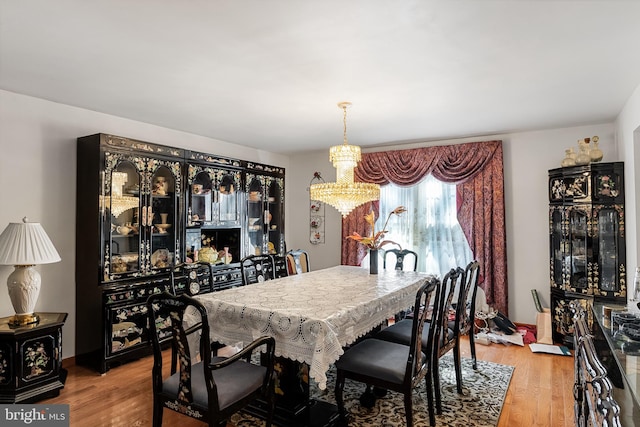 dining area with a chandelier and light hardwood / wood-style flooring