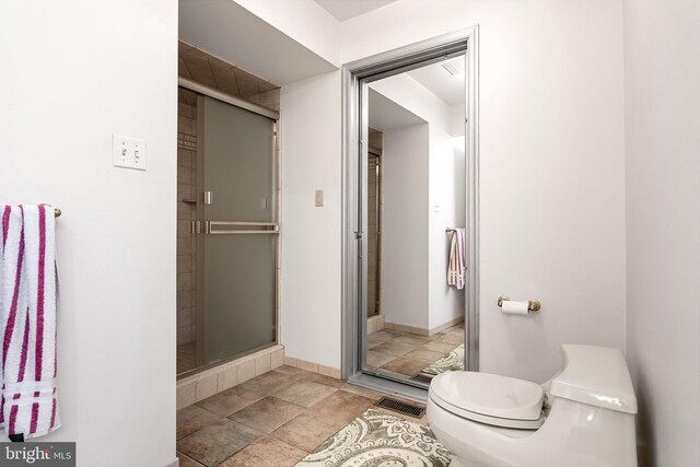 bathroom with toilet and an enclosed shower