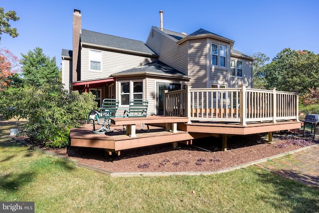 back of property featuring a yard and a deck