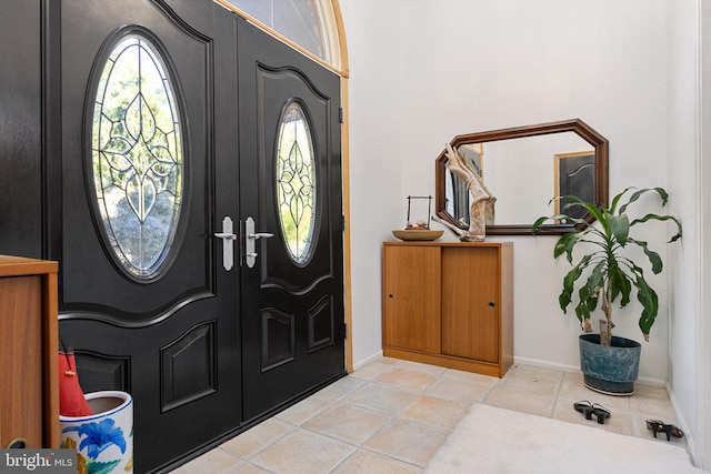 entryway with french doors and light tile patterned flooring