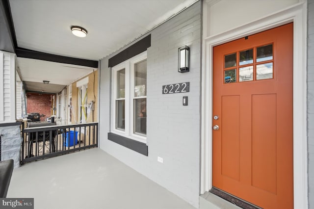 view of exterior entry featuring covered porch