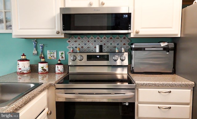 kitchen with white cabinets and appliances with stainless steel finishes