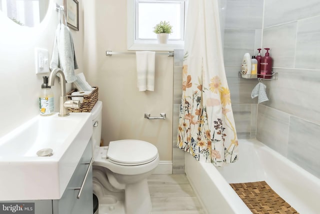 full bathroom with toilet, shower / bath combo with shower curtain, and vanity