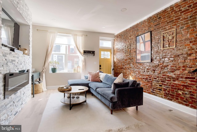 living room with light hardwood / wood-style flooring and brick wall