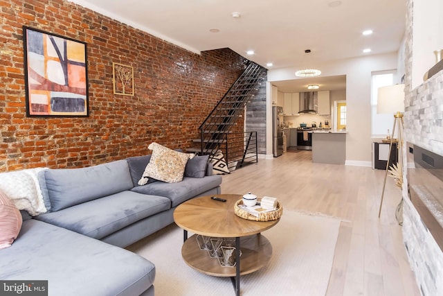 living room featuring brick wall and light wood-type flooring