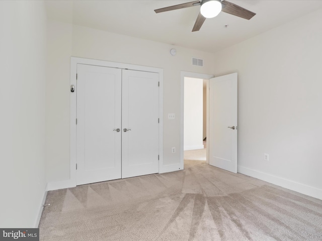 unfurnished bedroom featuring a closet, ceiling fan, and light colored carpet