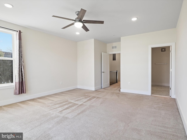 unfurnished bedroom with ceiling fan, light colored carpet, a walk in closet, and a closet