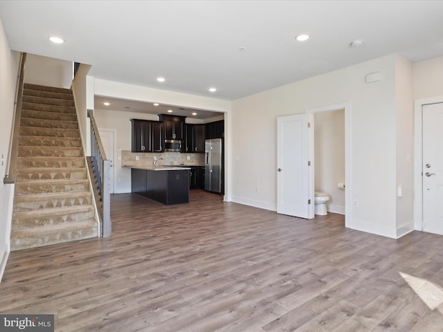 unfurnished living room with light hardwood / wood-style flooring and sink