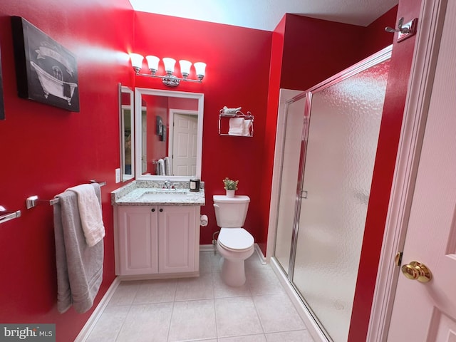 bathroom featuring an enclosed shower, vanity, tile patterned flooring, and toilet