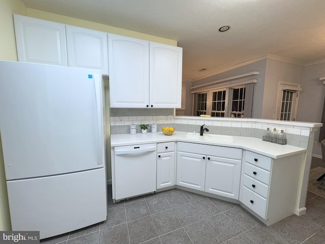 kitchen featuring sink, kitchen peninsula, white cabinets, white appliances, and backsplash