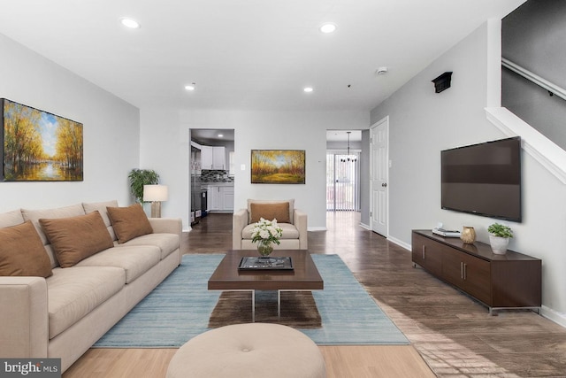 living area featuring recessed lighting, wood finished floors, baseboards, and a notable chandelier