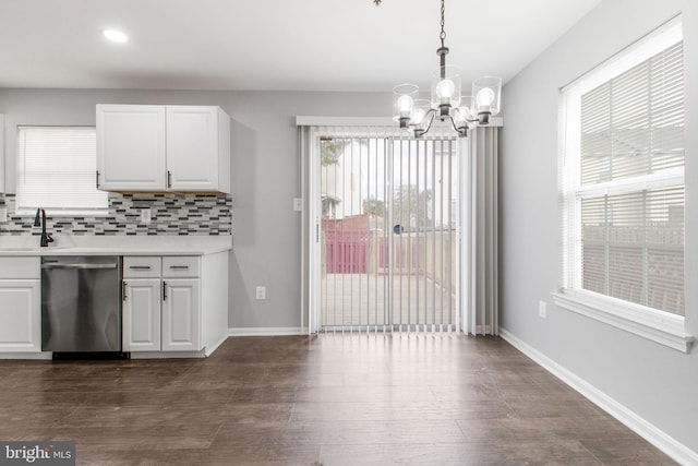 kitchen featuring an inviting chandelier, light countertops, dishwasher, a sink, and tasteful backsplash